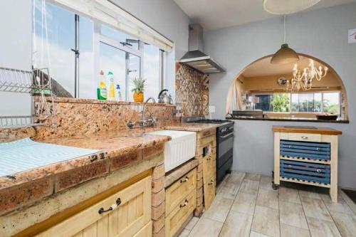 a large kitchen with wooden counters and a large window at FlowithLin Guesthouse in Durban