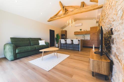 a living room with a green couch and a table at Gîte de La Sulpicière - avec clim in Cholet