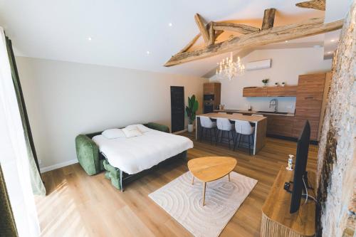 a living room with a bed and a kitchen at Gîte de La Sulpicière - avec clim in Cholet