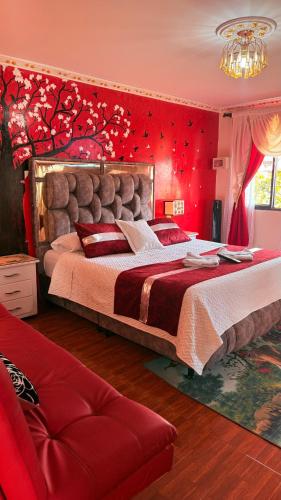 a bedroom with a large bed with a red wall at Posada Martha Tolima in Salento