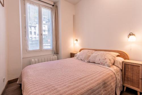 a white bedroom with a bed and a window at Appartement Centre Cauterets Calme, Confort, wifi et linge de maison inclus in Cauterets