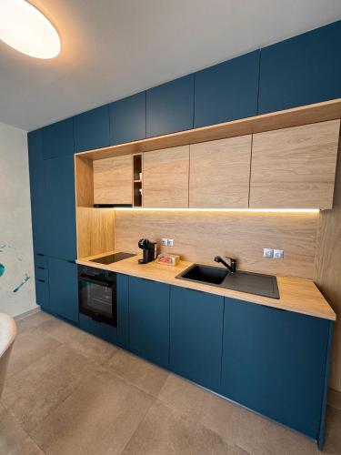a kitchen with blue cabinets and a sink at ATEA Apartments in Kavarna