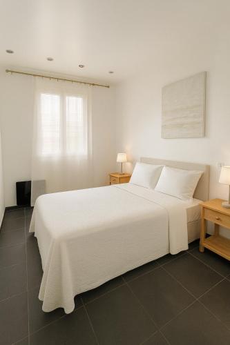 a bedroom with a large white bed with two tables at Les vacances in Sainte-Maxime