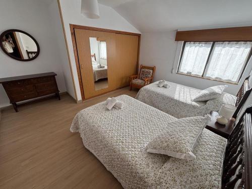 a bedroom with two beds and a mirror at Casa cerca de Las Medulas in Puente de Domingo Flórez