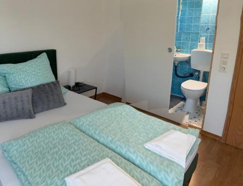 a bedroom with a bed and a bathroom with a toilet at Haus Sissi in Daun