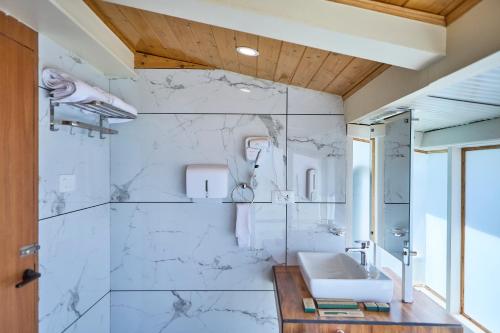 a bathroom with a sink and a marble wall at Ruscello in Pālampur