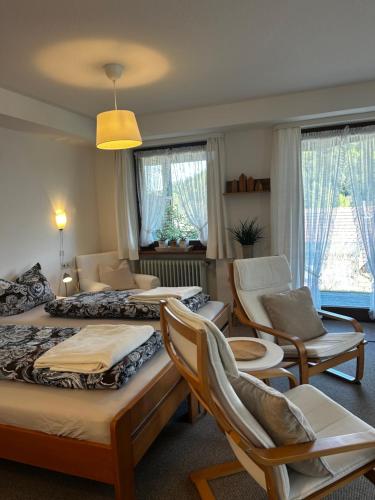 a hotel room with two beds and chairs at Ferienhaus Rotzinger in Hinterzarten