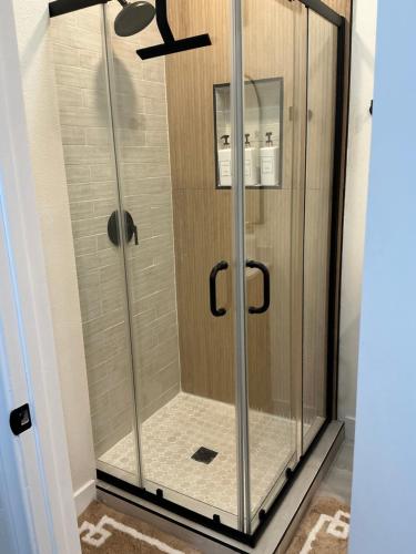 a shower with glass doors in a bathroom at Chic East LA Retreat 2 bedroom-sleeps 6-Near DTLA-Car Rental Service on Property in East Los Angeles