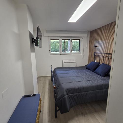 a bedroom with a blue bed and a window at Lido Appartamento Parcheggio Privato 400 mt dal mare in Lido di Camaiore