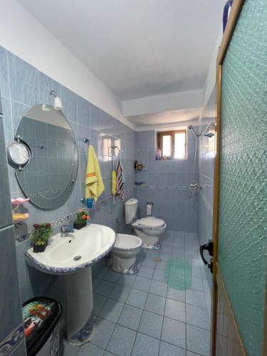 a bathroom with two toilets and a sink and a mirror at Summerland Lukovë in Sarandë