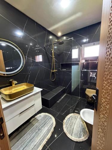 a bathroom with a sink and a toilet and a mirror at Villa Golden Sun in El Jemʼa Ghemat