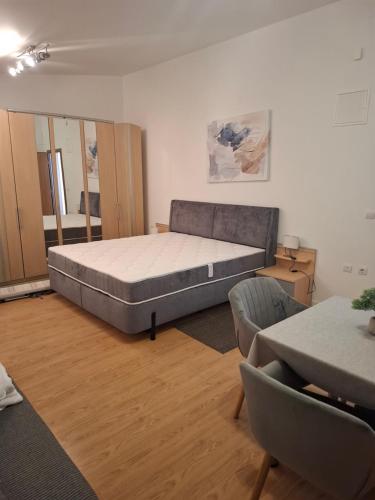 a bedroom with a bed and a couch and chairs at Apartmani MM in Tkon