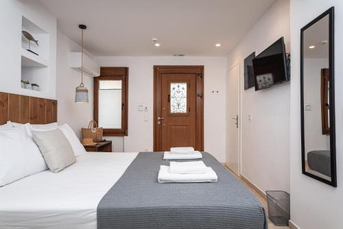 a bedroom with a bed and a tv on the wall at Kalami in Kokkari