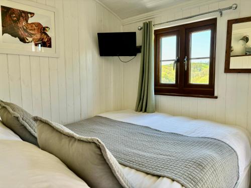 a small bedroom with a bed and a window at Fullabrook Farm Retreat, The Shepherdess Hut in West Down
