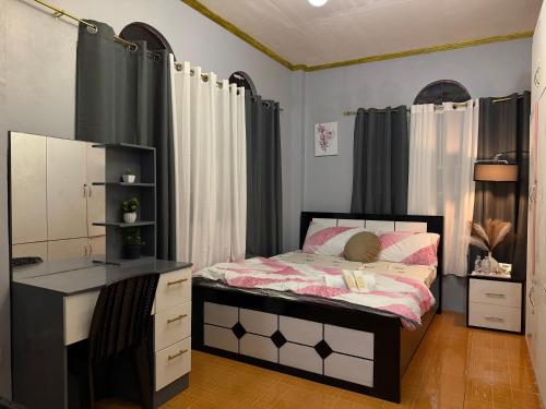 a bedroom with a bed with a dresser and a desk at AJM Iligan Homestay in Saray