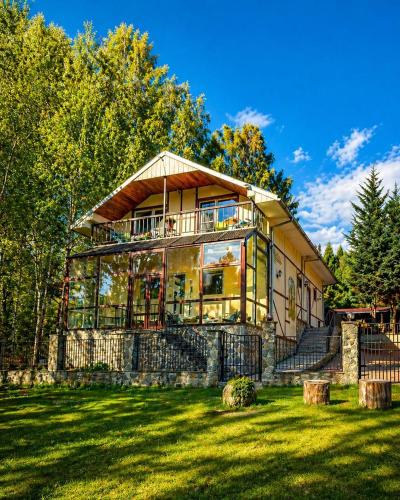 a large house on a hill with a green yard at Apfelhaus Poiana Marului in Poiana Mărului