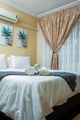 a bedroom with a large white bed with a window at Noah Garden in Johannesburg