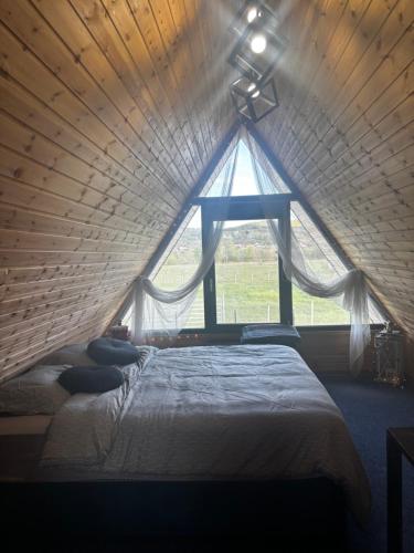 a bed in a room with a large window at LAKEVIEW A-frame ESCAPE in Tisa
