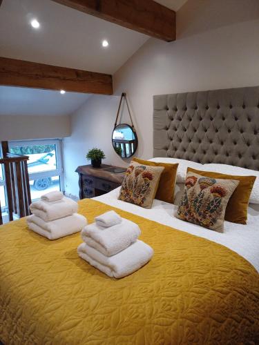 a bedroom with a large yellow bed with towels on it at south view farm cottage 1 Bed in Bradford