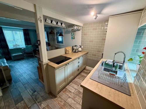 a kitchen with a sink and a counter top at Oligrae Cottage in Bridport