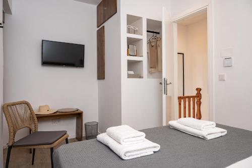 a room with a bed and a table and a tv at Kalami in Kokkari