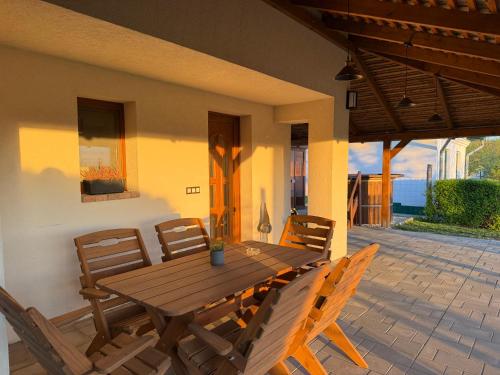 a wooden table and chairs on a patio at Horizont Haus in Tevel