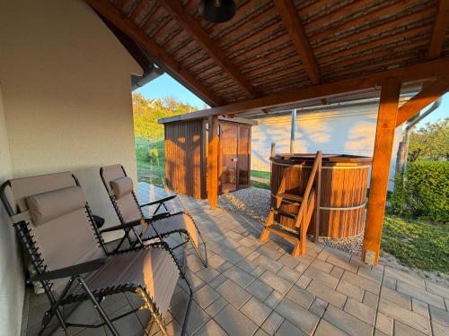 a patio with two chairs and a tub on a patio at Horizont Haus in Tevel