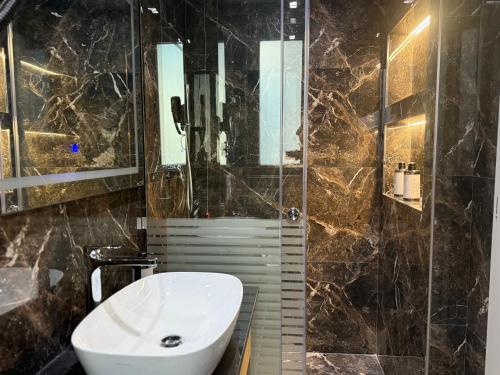 a bathroom with a sink and a glass shower at Vila-L Hotel in Tirana