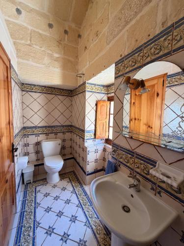 a bathroom with a toilet and a sink at Stella & Stone Guesthouse in Għarb