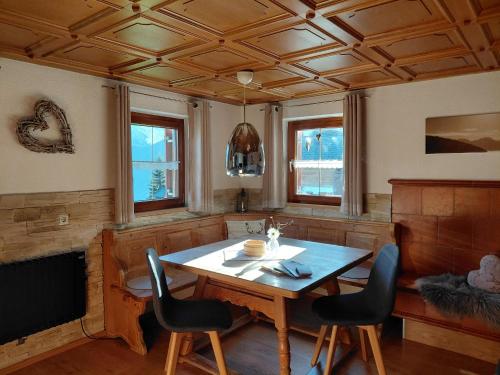 a dining room with a wooden table and chairs at Alphüsli Garfrescha in Sankt Gallenkirch