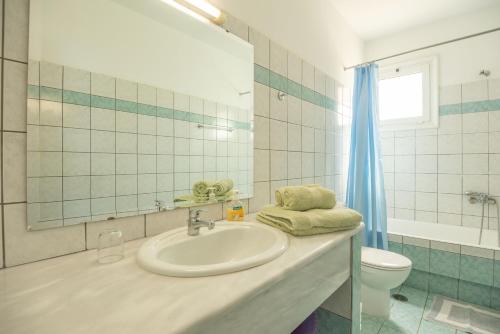 a bathroom with a sink and a toilet at Poppy Villas in Agios Nikolaos