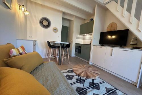 a living room with a couch and a small kitchen at The beachside coquette in Frontignan