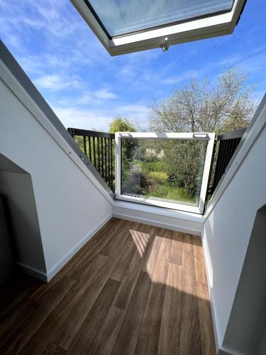 a room with a balcony with a large window at Modern Attic Loft in Weisenheim am Sand