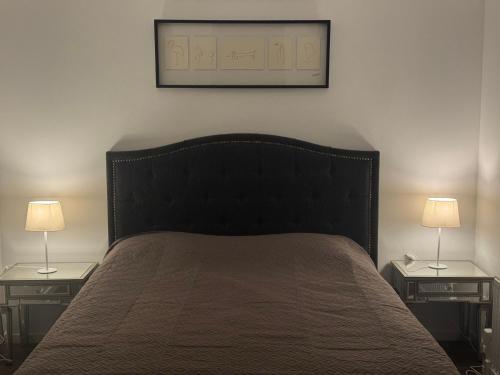 a bedroom with a bed with two nightstands and two lamps at Sollidsvägen 1 F in Bro