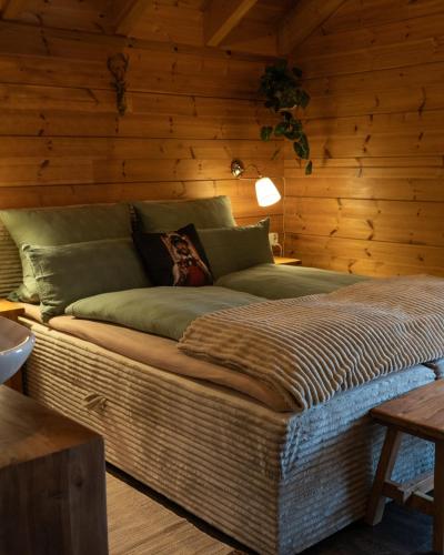 a large bed in a room with wooden walls at Sohana Chalet I Design I Apartment and Guest Rooms I Sauna I AC in Kappel-Grafenhausen