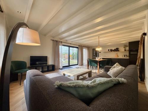 a living room with a couch and a table at Luxe recreatiebungalows midden in bosrijke omgeving Waalre Noord-Brabant in Waalre