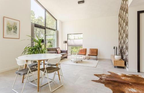 a living room with a table and chairs at Luxe recreatiebungalows midden in bosrijke omgeving Waalre Noord-Brabant in Waalre