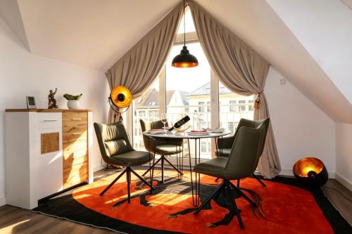 a dining room with a table and chairs in front of a window at Altstadt Suites am Kamp, Parkhaus möglich in Paderborn