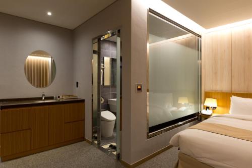 a bathroom with a bed and a sink and a mirror at Incheon Stay Hotel in Incheon