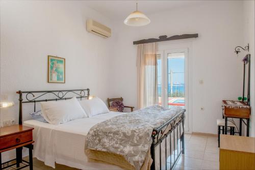 a bedroom with a bed and a window with a view at Poppy Villas in Agios Nikolaos