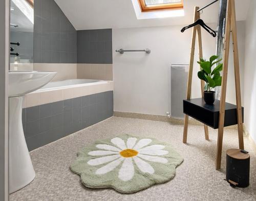 a bathroom with a sink and a bath tub and a flower rug at Le loft de l'entrepote in Argenton-sur-Creuse