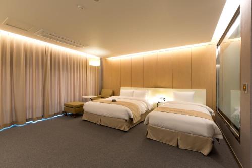 a hotel room with two beds and a flat screen tv at Incheon Stay Hotel in Incheon