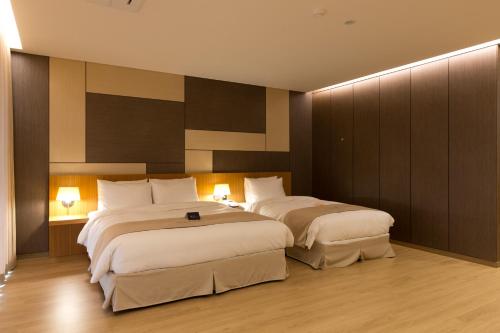 two beds in a hotel room with two lamps at Incheon Stay Hotel in Incheon
