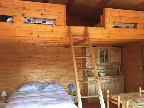 a bedroom with a bunk bed in a log cabin at Chalet l'écureuil in Treigny