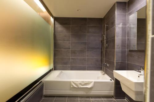 a bathroom with a bath tub and a sink at Incheon Stay Hotel in Incheon