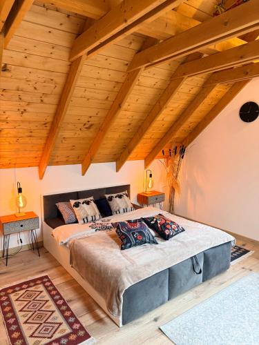 a bedroom with a large bed with wooden ceilings at Nadbużańska Ostoja in Kamieńczyk