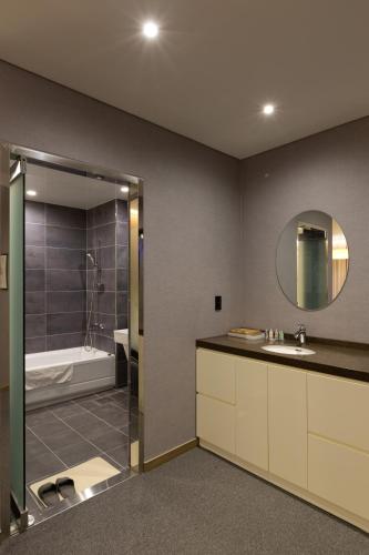 a bathroom with a sink and a bath tub at Incheon Stay Hotel in Incheon
