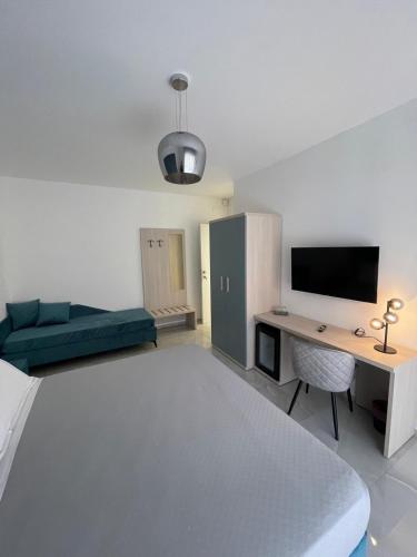 a living room with a couch and a desk with a tv at Gheloi Room in Gela