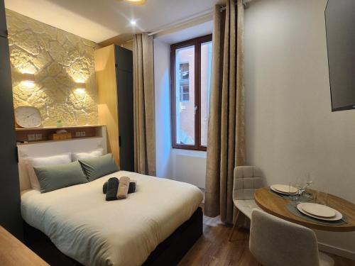 a hotel room with a bed and a table and a tableablish at Charming cozy nest - old town in Annecy