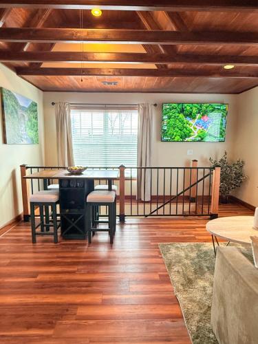 a living room with a table and a tv on the wall at Sunlit Loft, Near GSP and Private Entry in Greer